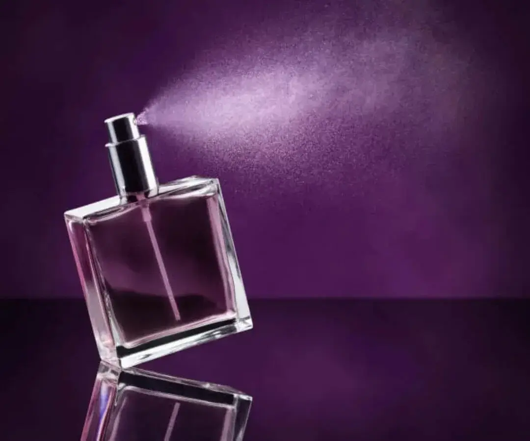 Elegant bottle of ORA's Crimson Dusk perfume against a dark, moody background.