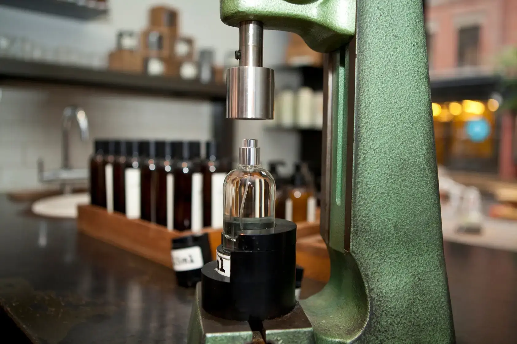 A machine carefully filling a perfume bottle.