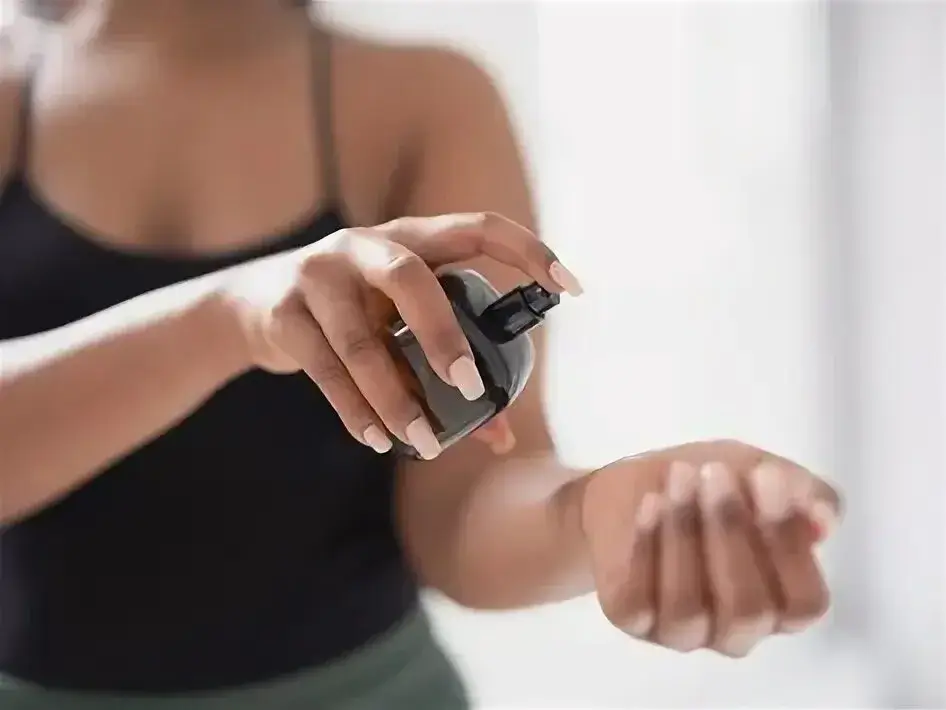 A person elegantly spraying perfume on their wrist.